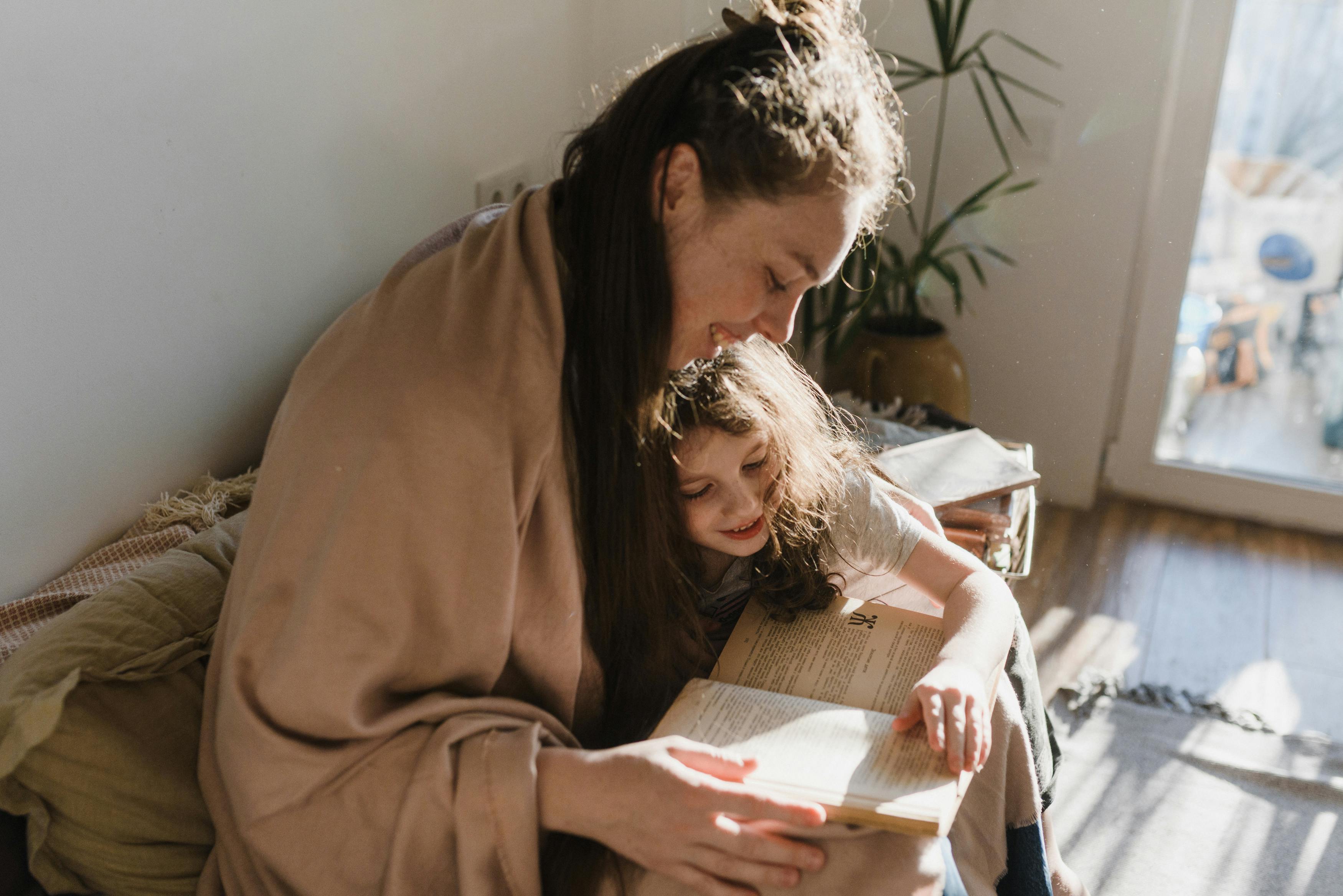 Mulher lendo livro em cadeira aconchegante com filho - espaço perfeito para relaxar.